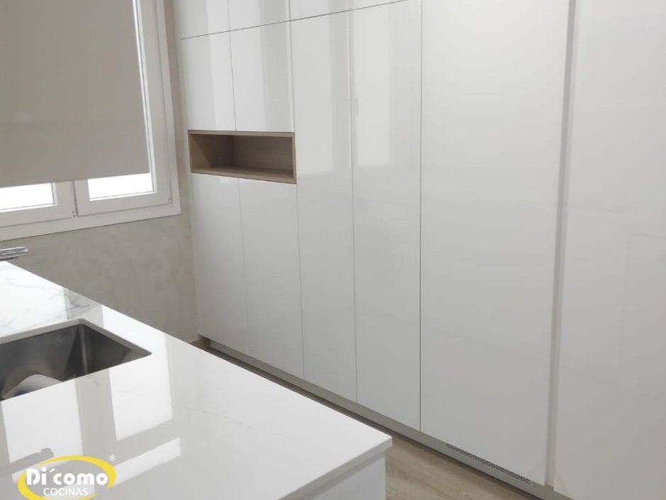 Columnas de alacena blancas de suelo a techo con una hornacina de madera en una cocina moderna