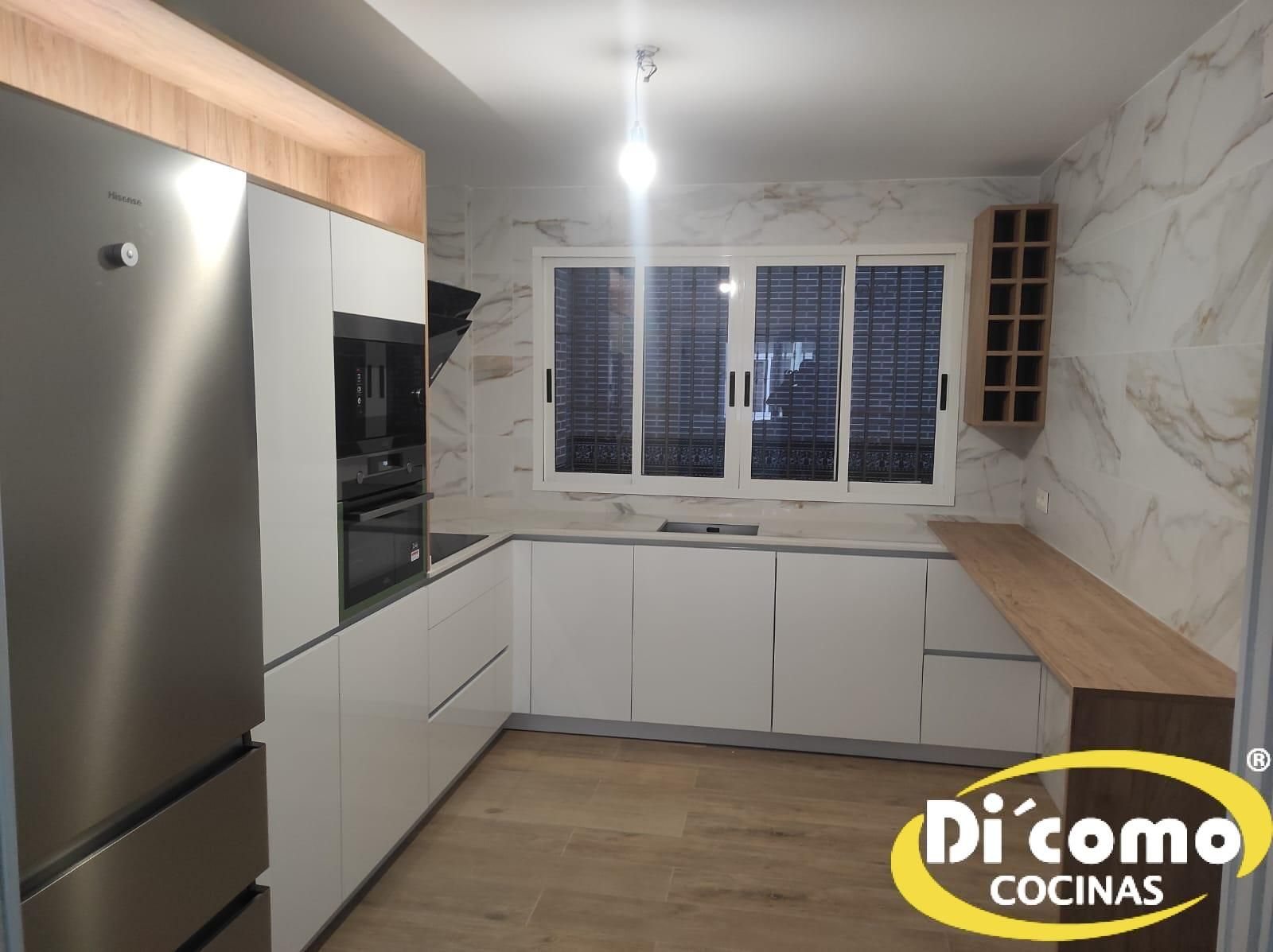 Cocina moderna blanca en U con encimera de madera, frontal efecto mármol y botellero de madera
