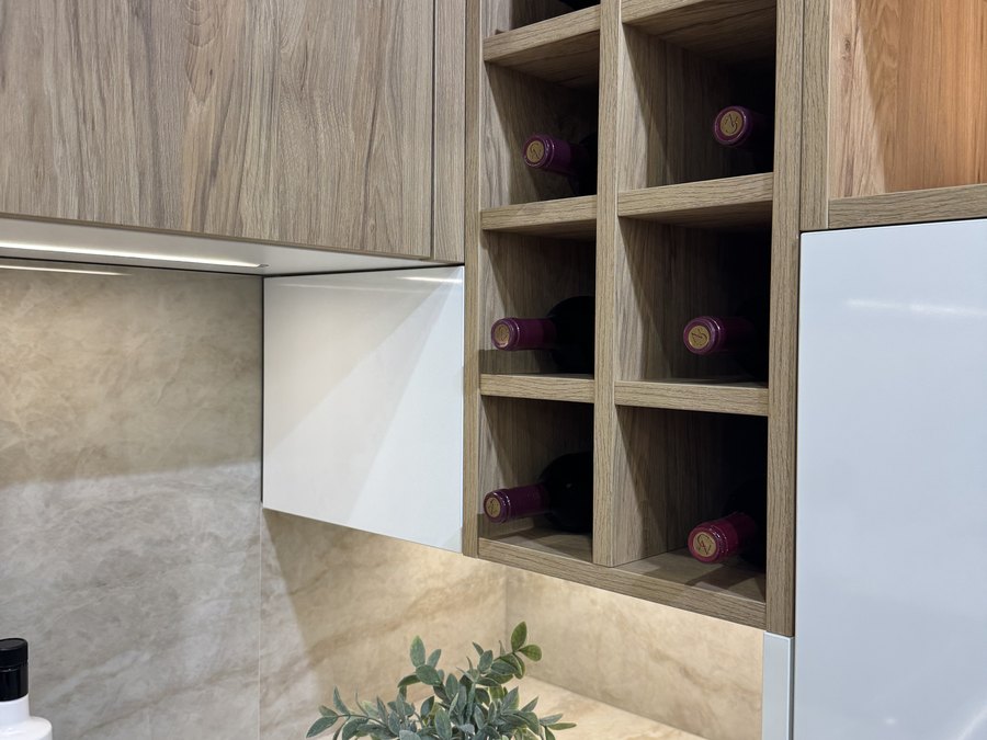 Botellero de madera con vetas naturales integrado en el mueble alto